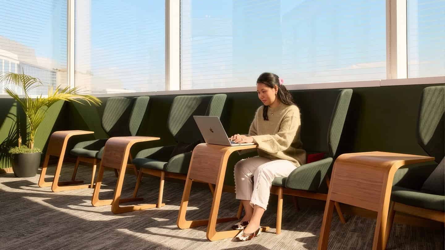 An amber team member working in a sunlit office lounge