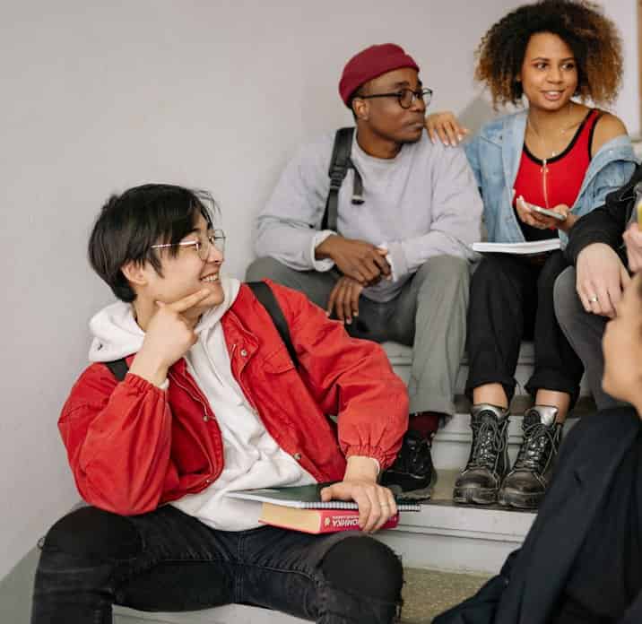 Four friends sitting around a table in the kitchen of a shared flat